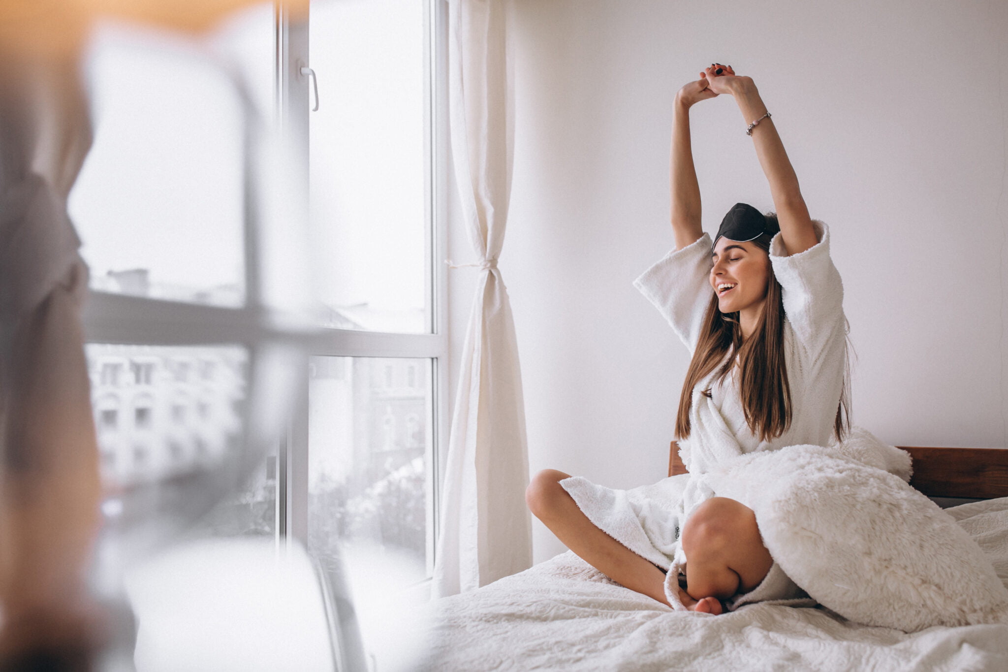 mujer en la cama estirando los brazos mujer en la cama estirando los brazos